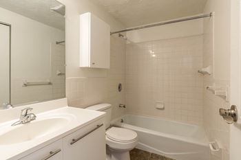 A bathroom with a sink toilet and a bath tub